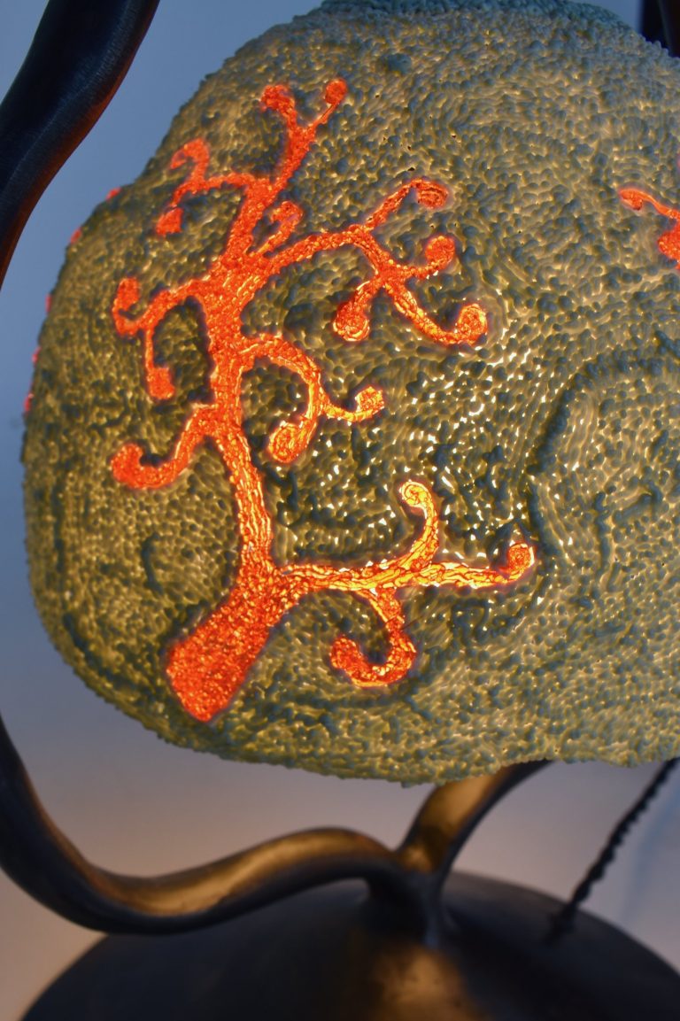 Close-up of a Peloria shade: grey recycled plastic with an orange coral motif