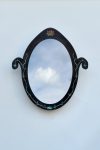 Pietra Plastica oval mirror in black steel inlaid with recycled plastic vines and a small rosette