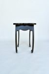 Pietra Plastica side table in black patinated steel with curling legs