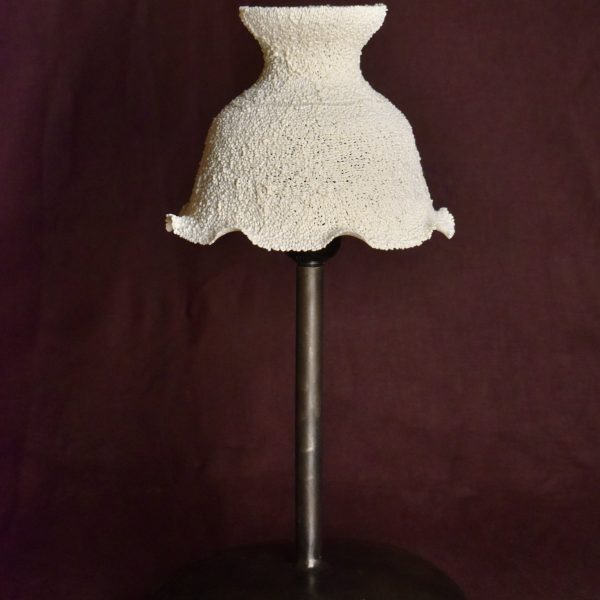 Small lamp with a white ruffled recycled-plastic shade on a dark metal stand